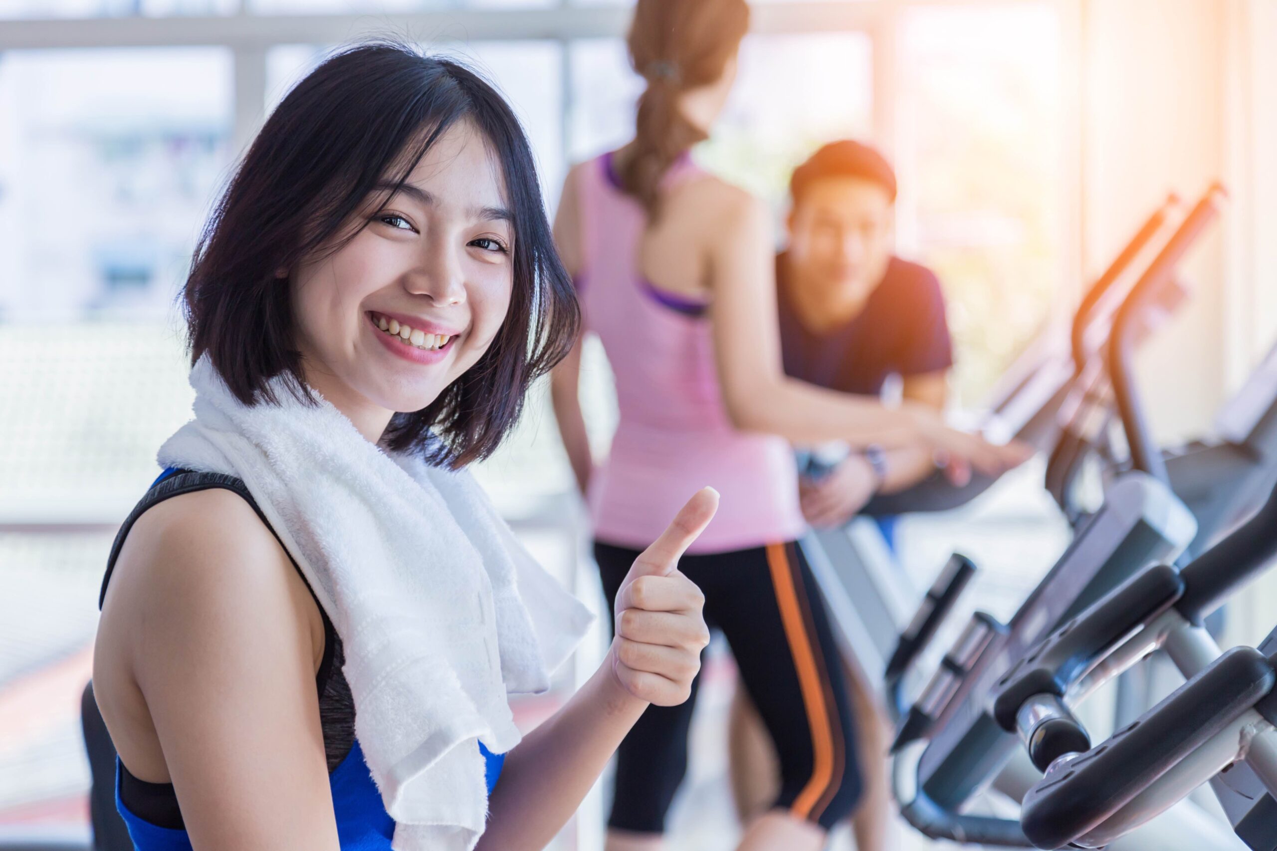 トレーナーのサポートで猫背改善に取り組む女性の様子
